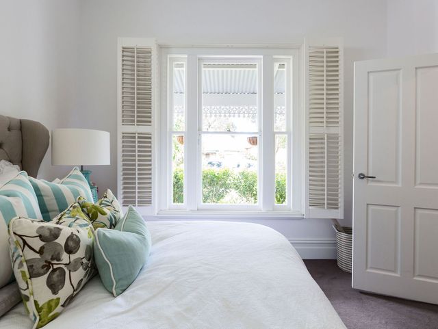 White shutters installed in a bedroom